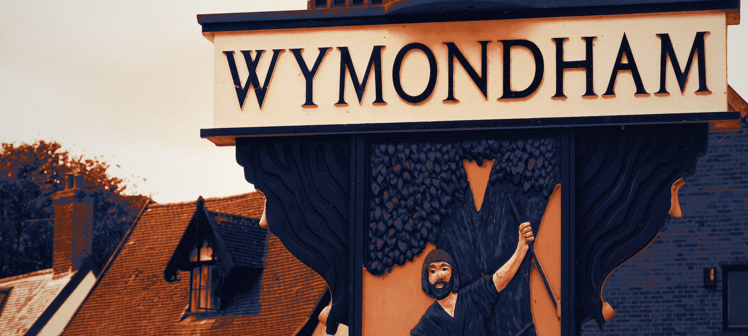 Wymondham village sign with a Tudor timber-framed building behind, Norfolk.